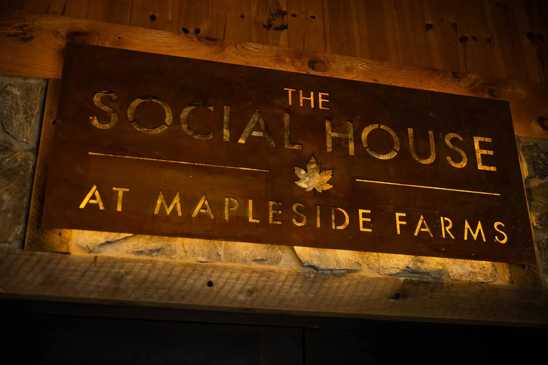 The Social House at Mapleside Farms sign, lit from behind