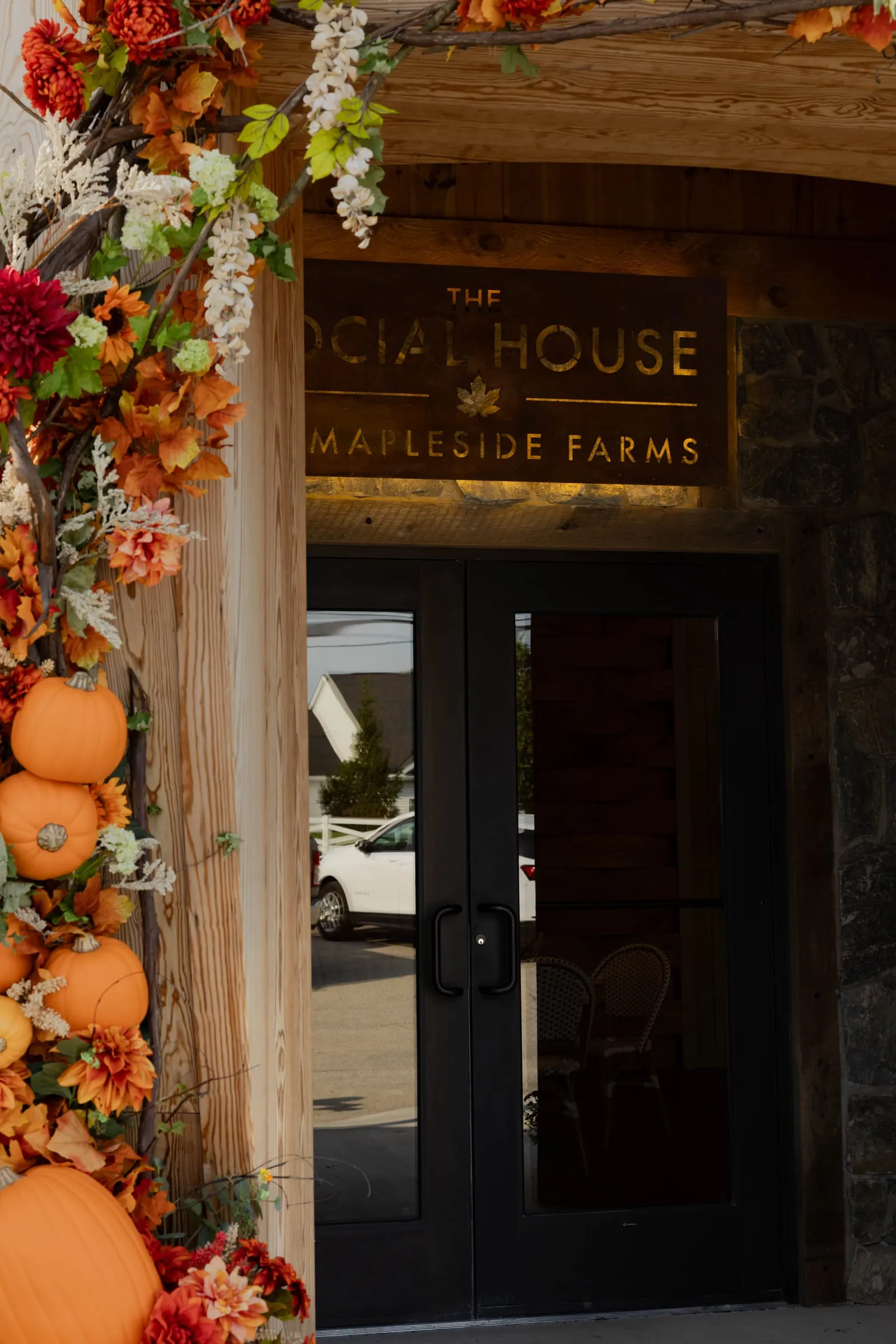 A fall-decorated doorway beneath The Social House sign