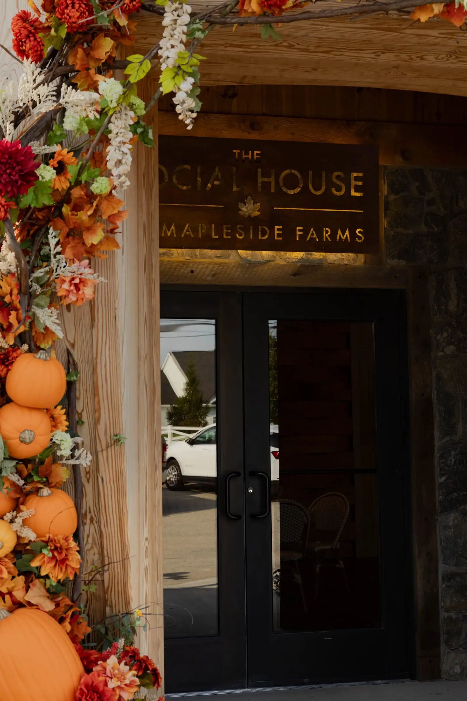 A fall-decorated doorway beneath The Social House sign
