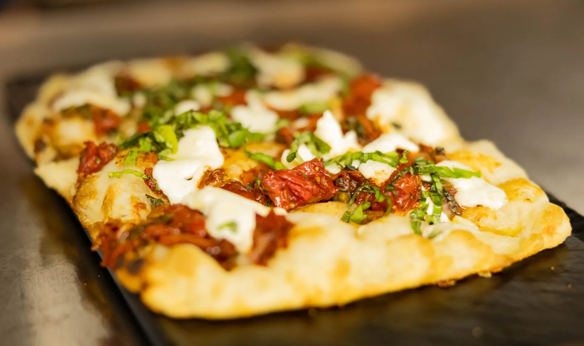 Flatbread topped with tomatoes, fresh mozzarella and basil