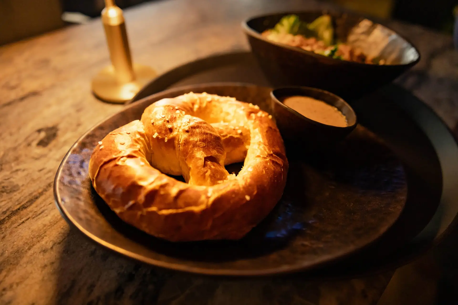 A soft pretzel with dipping sauce at The Social House