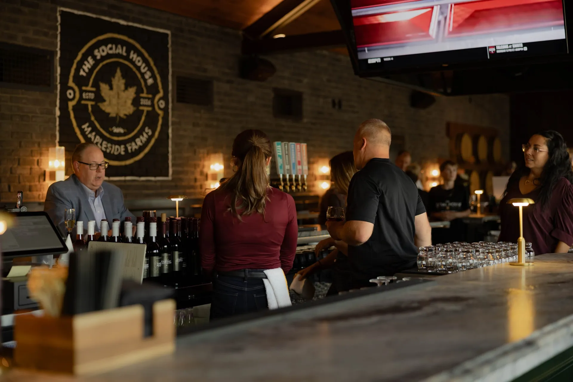 Guests gathered at the central bar beneath The Social House emblem