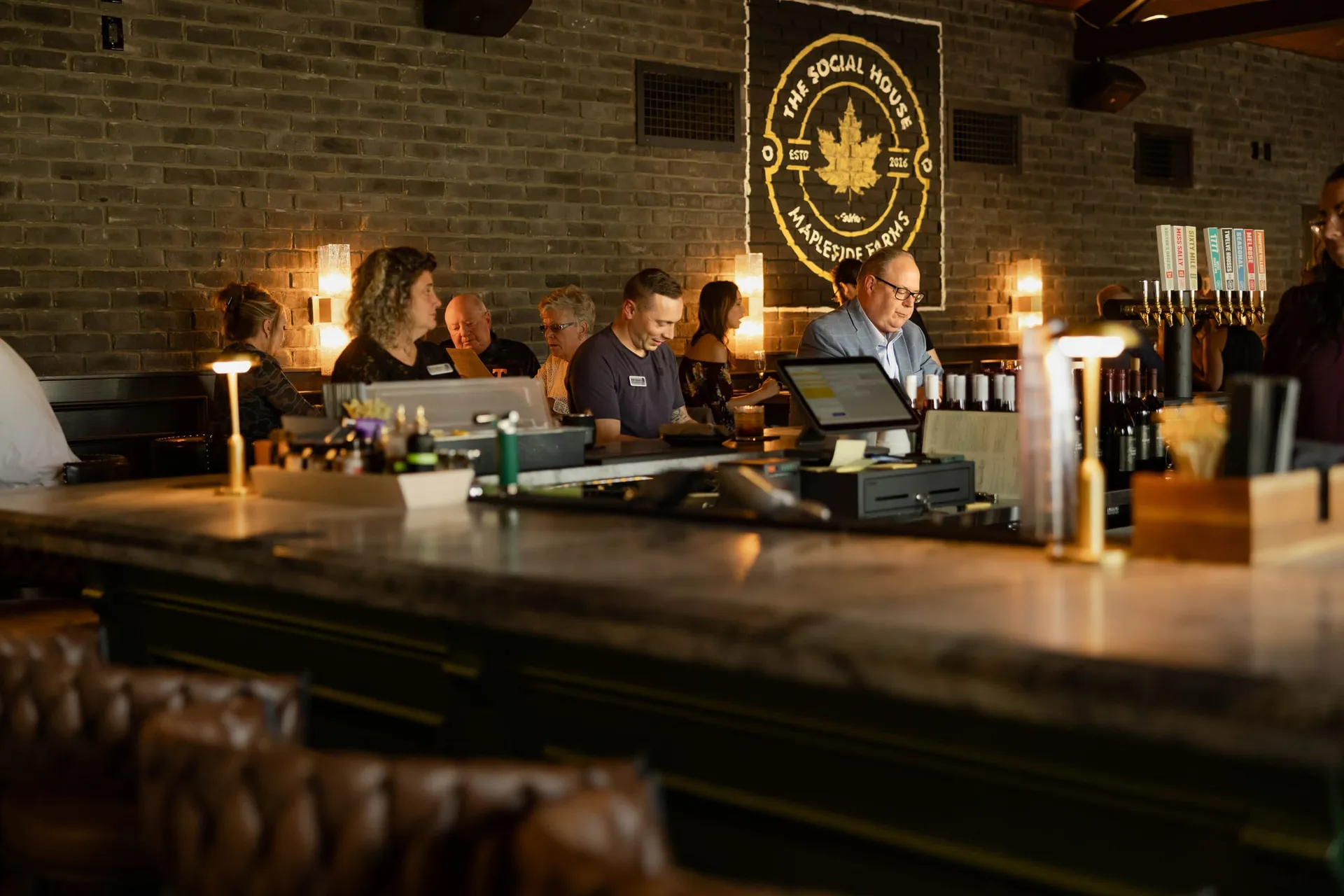 Guests seated along the central bar in The Great Room