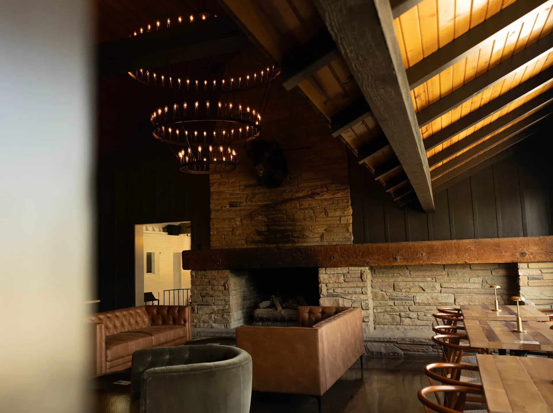 Stone fireplace lounge and high-top seating under the vaulted ceiling of The Great Room