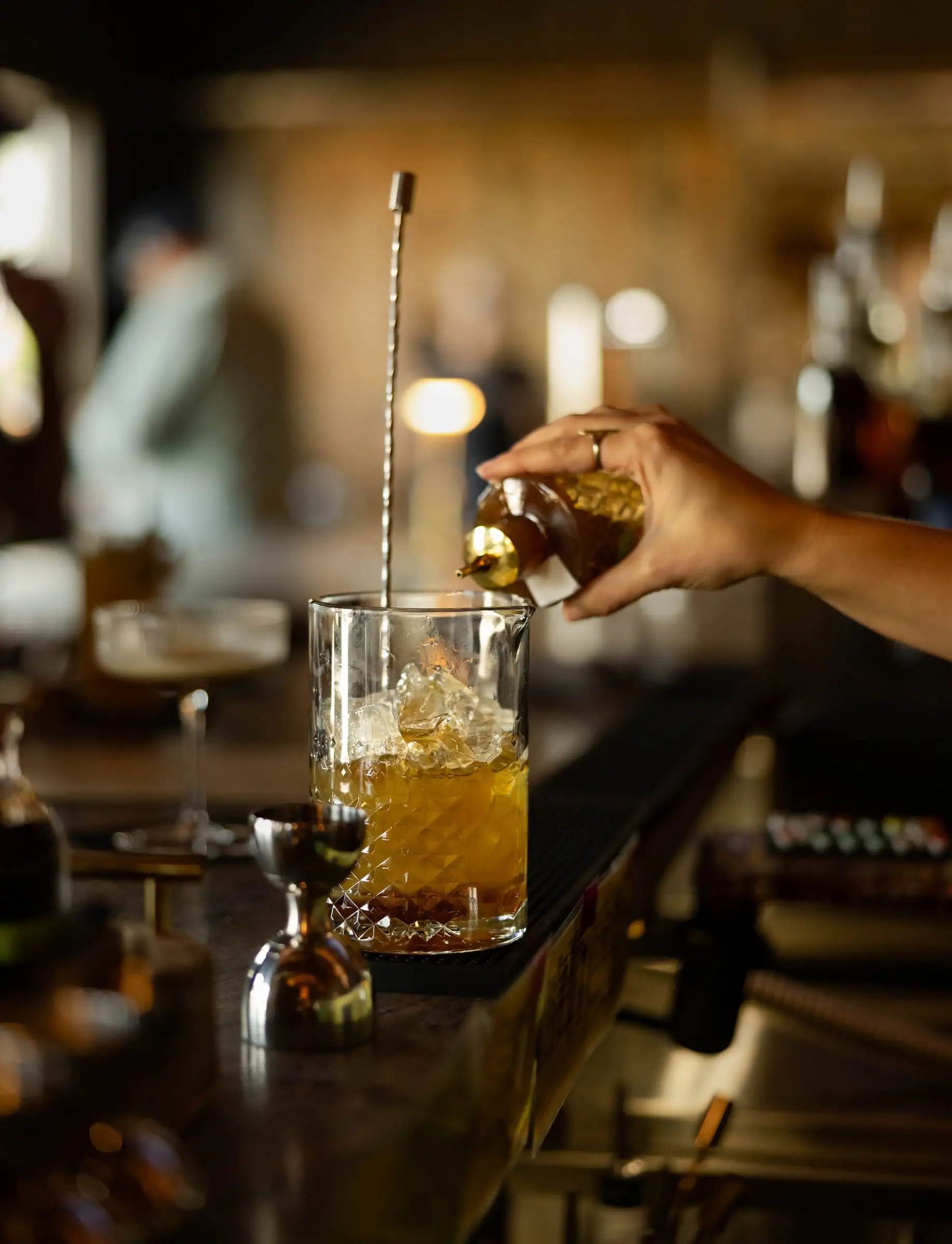 Bartender pouring a cocktail over ice