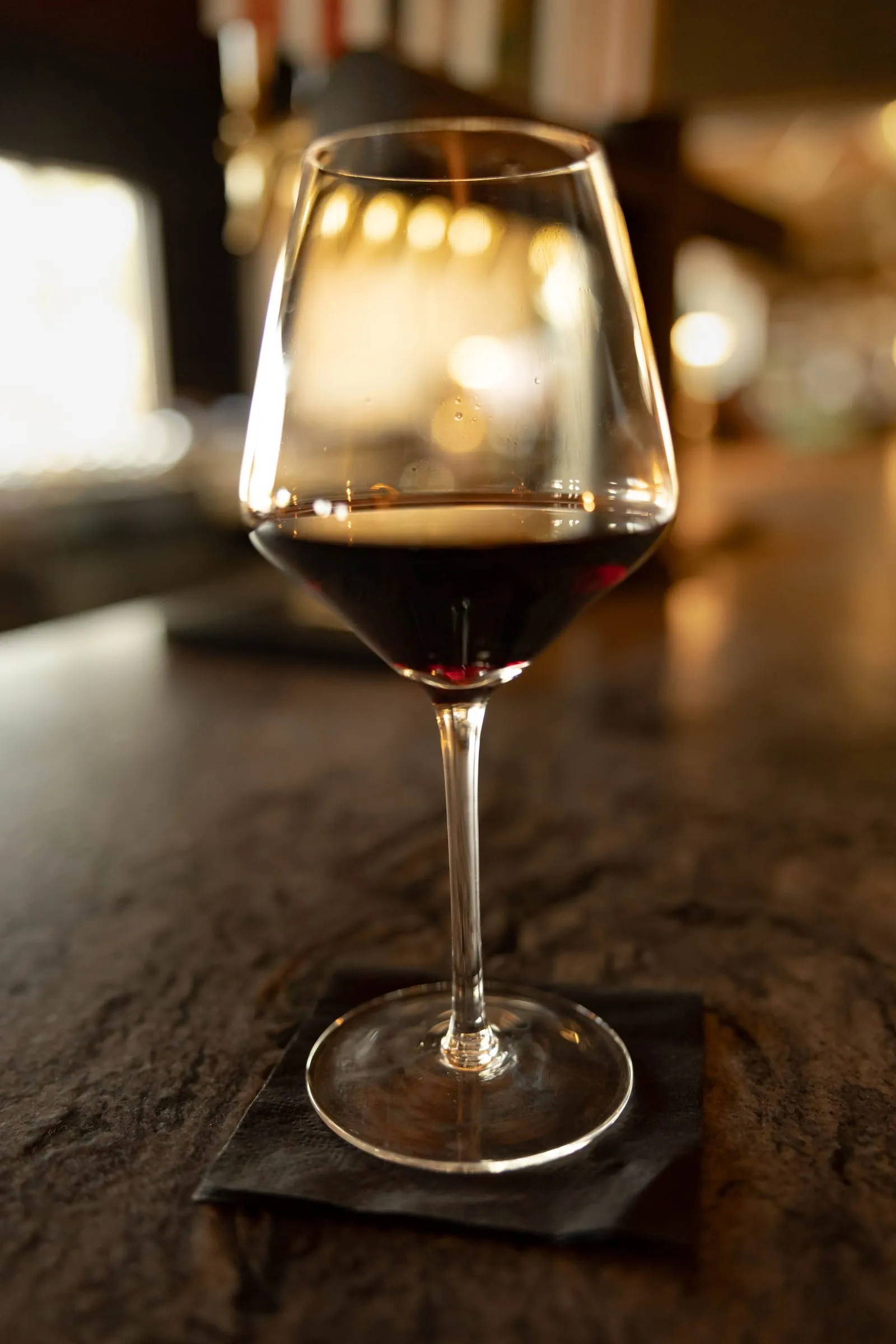 A glass of red wine on the bar top