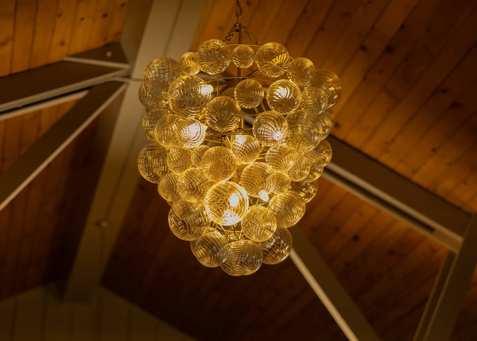 Amber glass chandelier against the wood ceiling of The Library