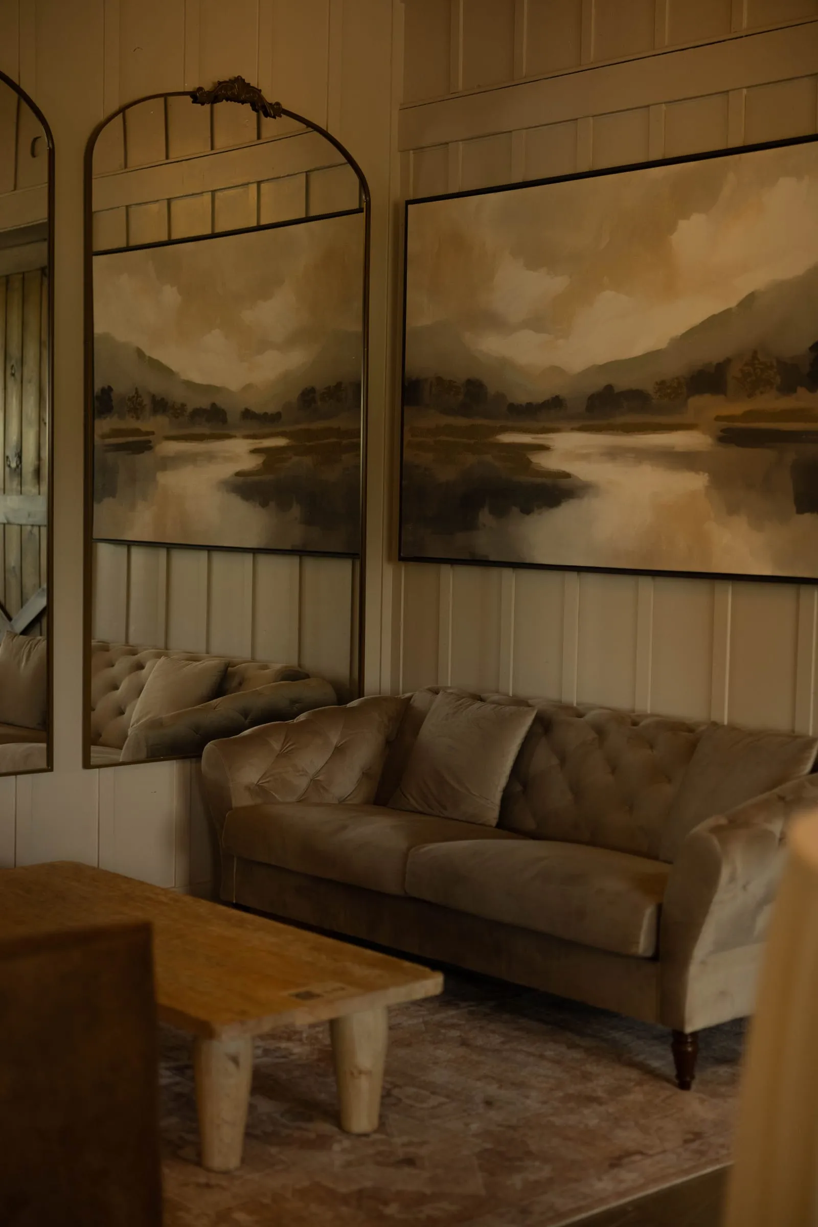 Leather sofa beneath landscape paintings in The Library
