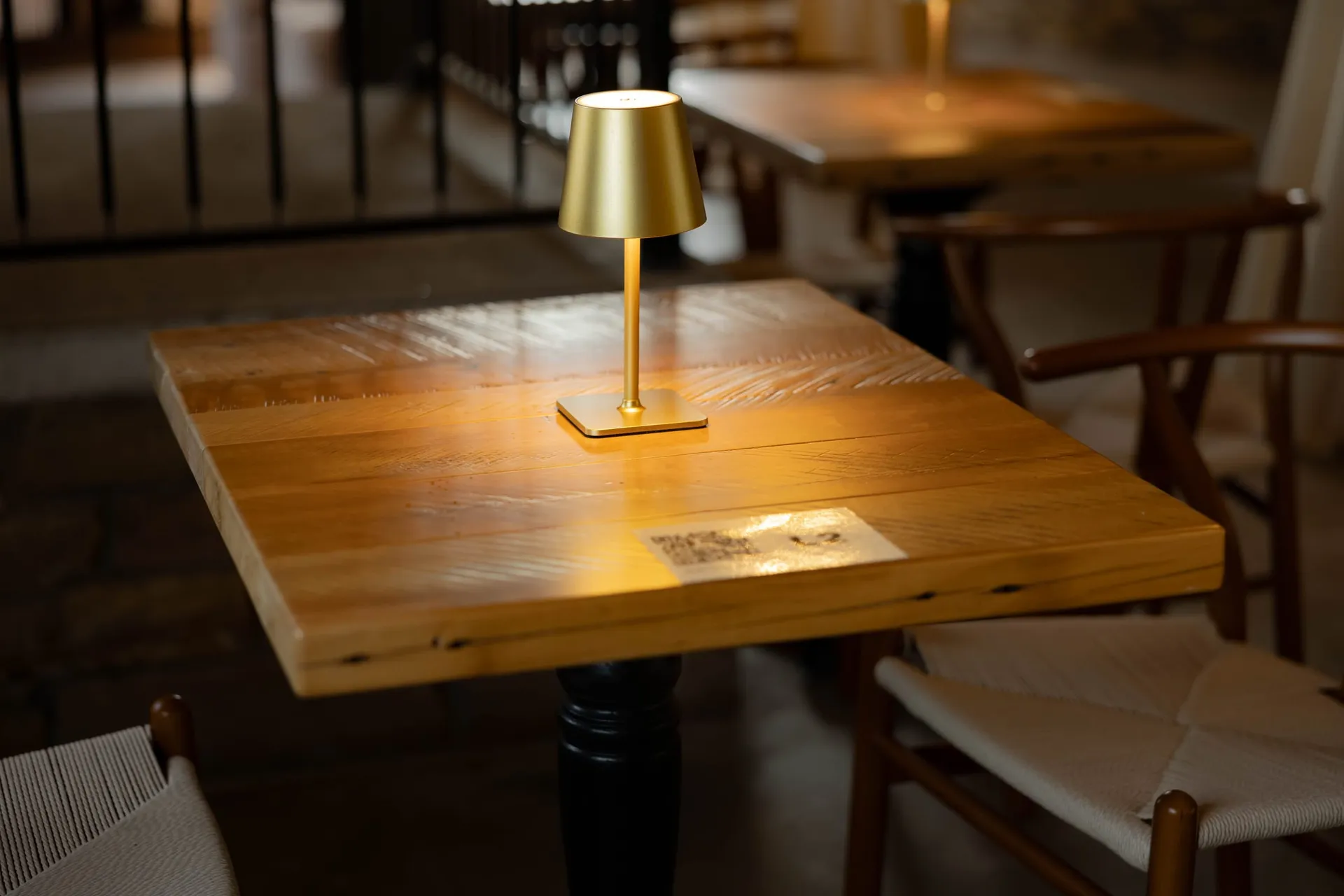 A brass lamp on a wood table in The Library