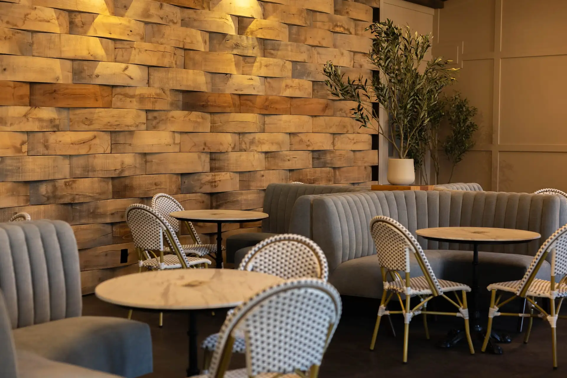 Tufted banquettes and bistro tables against the barrel-stave wall in The Press at The Social House, Mapleside Farms