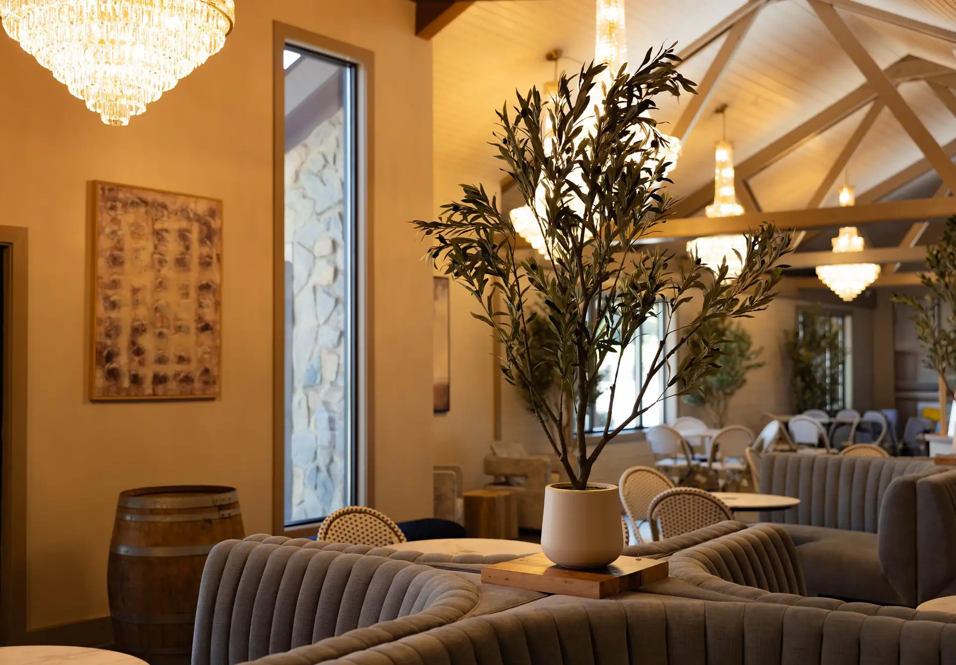 The Press dining room with olive trees and crystal chandeliers