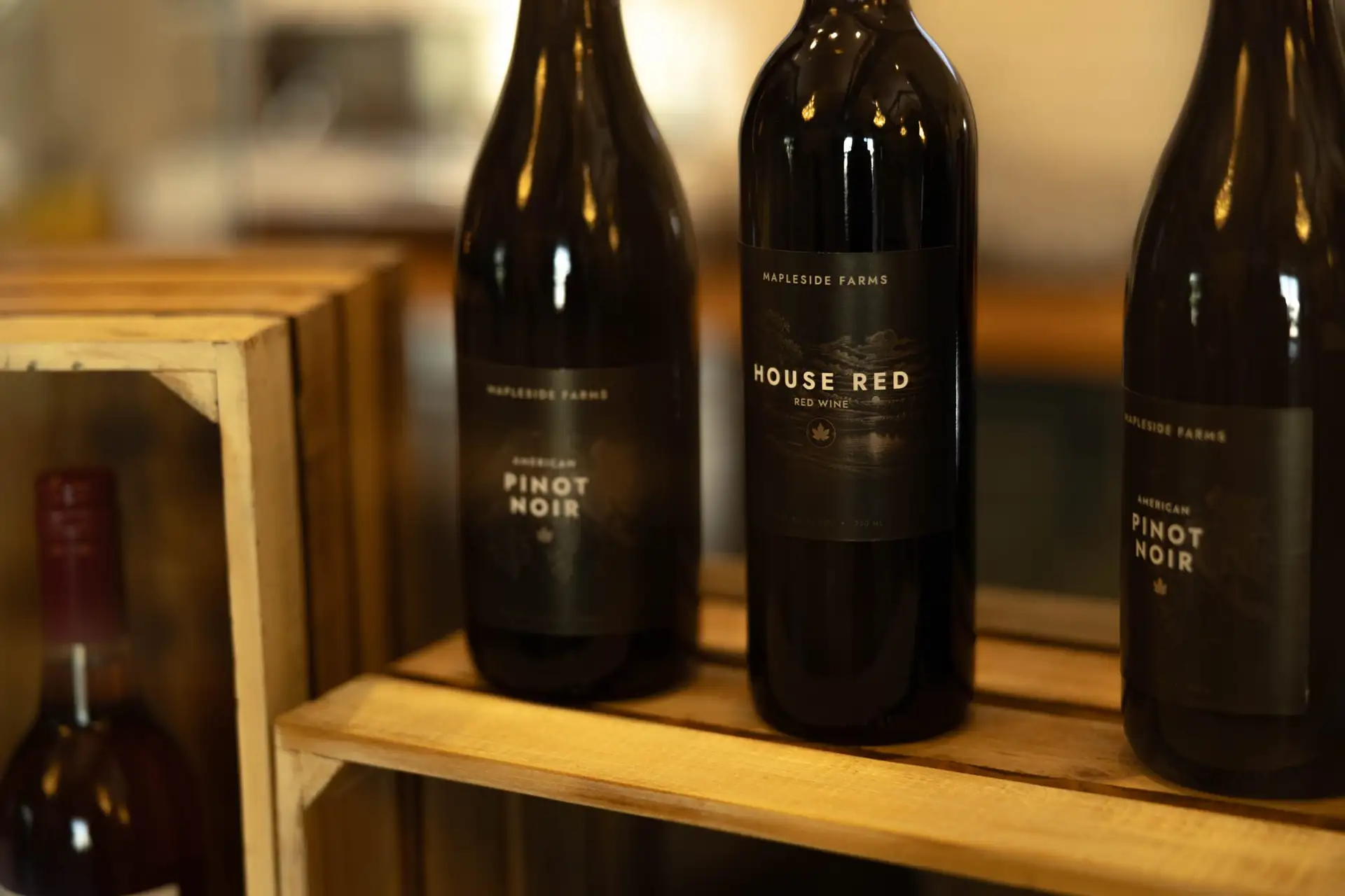 Mapleside Farms Pinot Noir and House Red on a wooden shelf